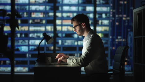 Portrait-of-Thoughtful-Successful-Businessman-Working-on-Laptop-Computer-in-His-Big-City-Office-at-Night.-Data-Analysis-for-e-Commerce-Strategy